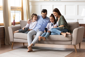 Family in living room. All Seasons Heating and Cooling provides electric furnace installation in Vancouver WA and Camas WA.