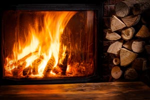 Fully lit fireplace in home. - All Seasons Heating & Cooling provides expert fireplace insert installation services in Vancouver WA and Camas WA. 