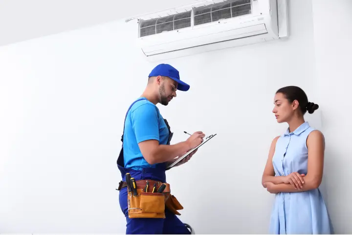 Professional HVAC technician speaking with a woman about indoor air quality systems