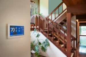 smart thermostat near a wooden staircase inside a Pacific Northwest home