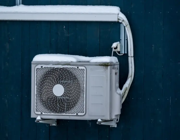 heat pump outside portland home after light dusting of snow during winter storm